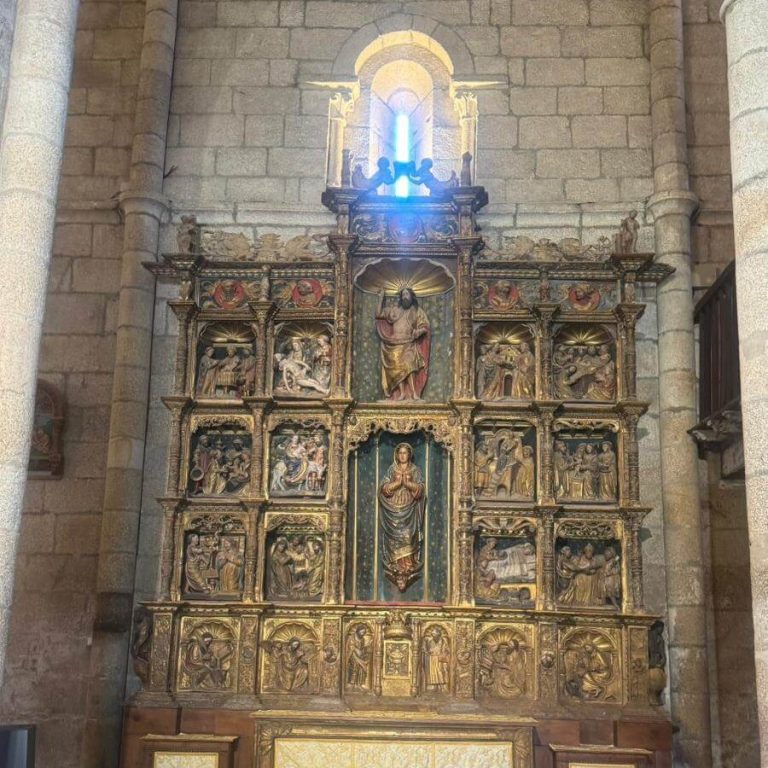 Gran retablo renacentista de madeira dourada dividido en varios cadros e niveis, cheo de figuras e relevos relixiosos tallados.