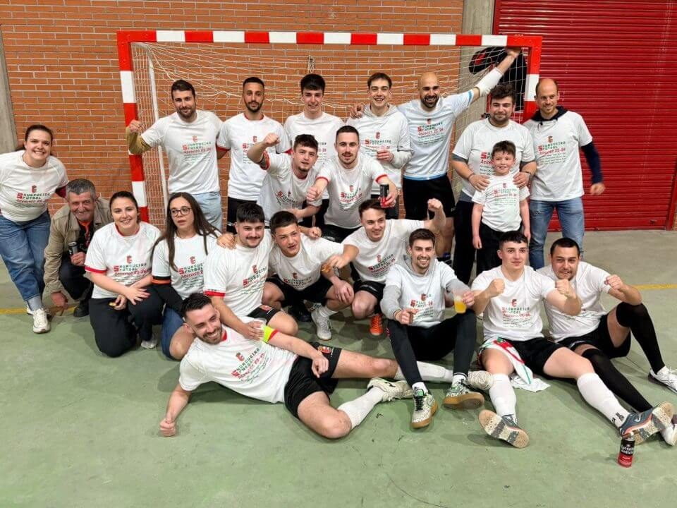 Equipo 5Xunqueira Futsal Fotografía de grupo do equipo local de fútbol sala, formado por mozos e mozas con camisetas brancas, posando riseiros e abrazados na pista