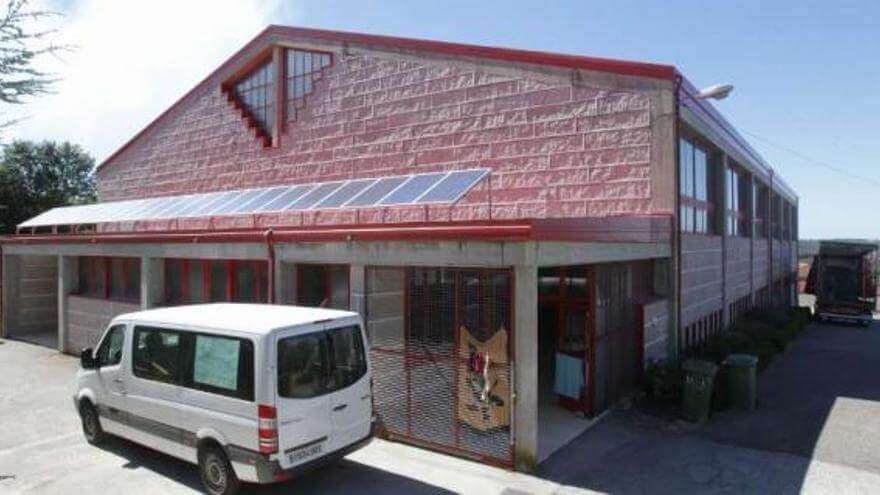 Polideportivo Edificio de deseño contemporáneo con fachada de paneis de cor tella, grandes ventás na planta baixa, paneis solares no tellado.